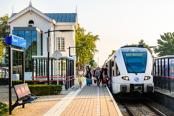 Mensen stappen op het station in Reuver in de Arriva trein naar Roermond